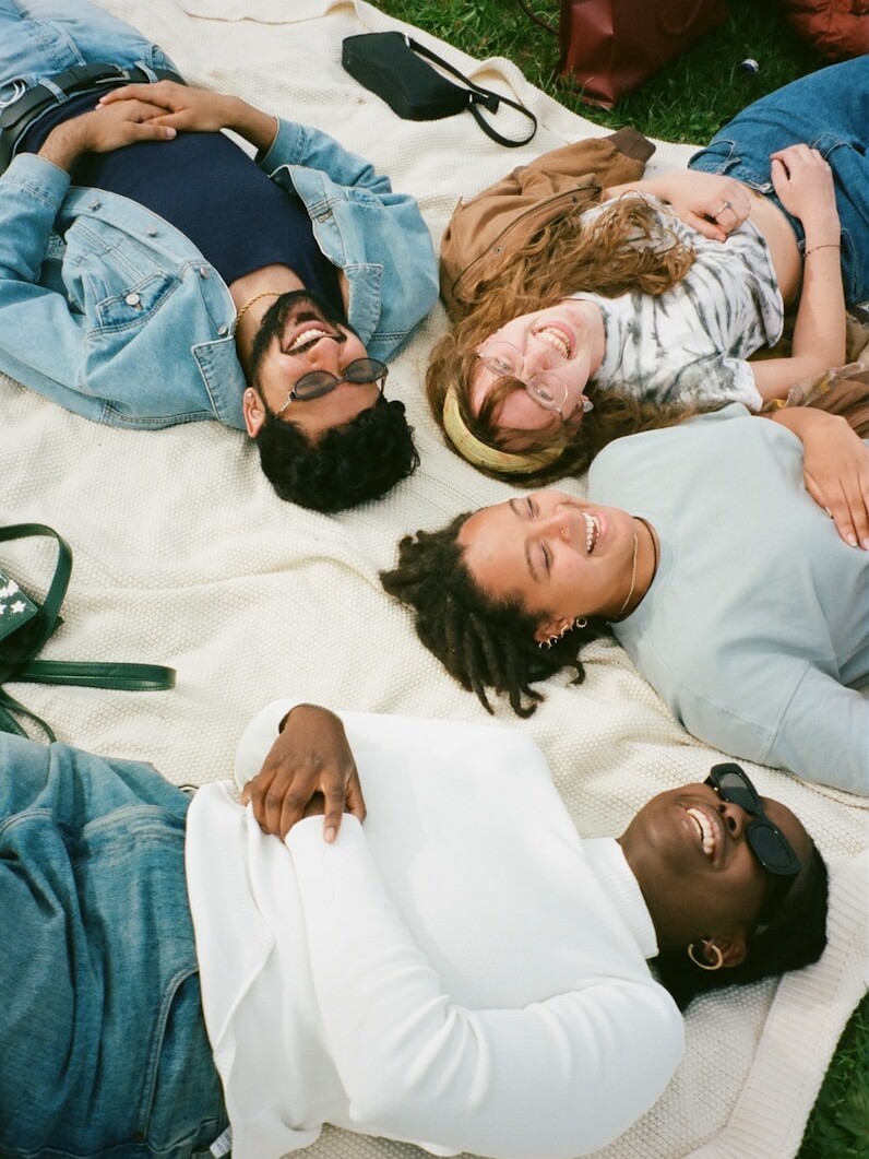 man in blue button up shirt lying on white bed