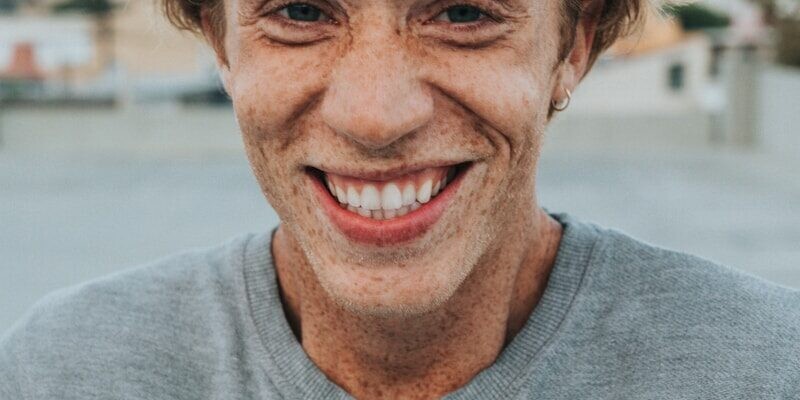 man in gray crew neck shirt smiling