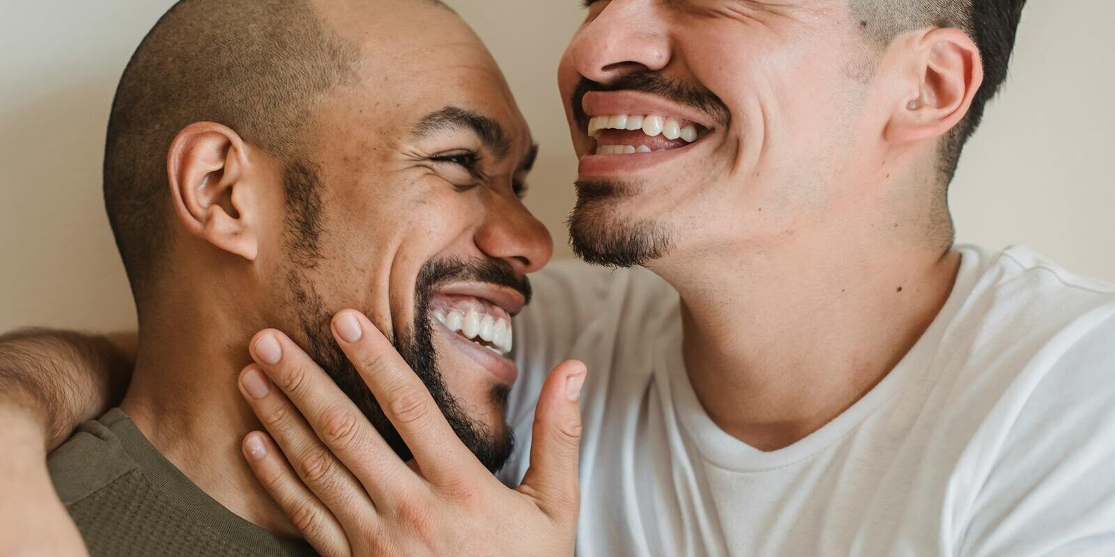 A close-up of a happy couple sharing a joyful embrace and smiling warmly at each other.