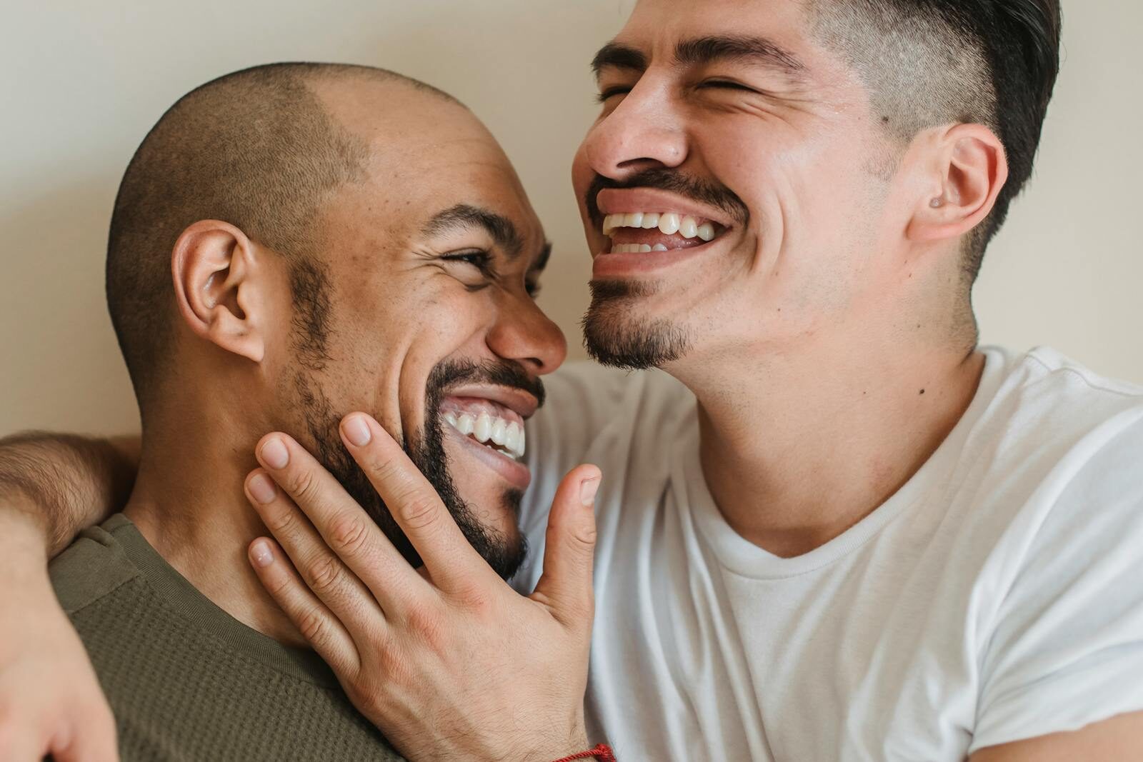 A close-up of a happy couple sharing a joyful embrace and smiling warmly at each other.