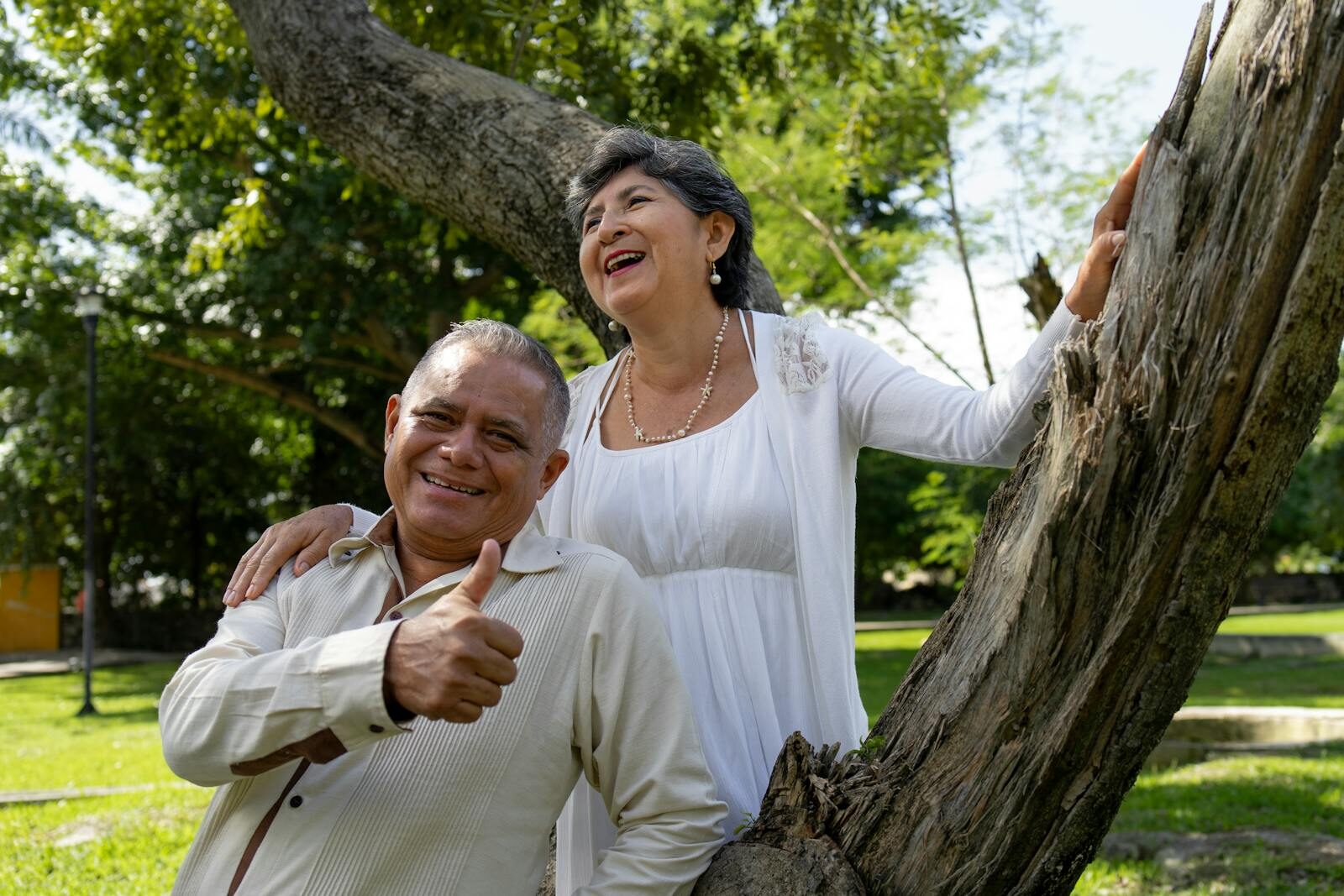 Happy senior couple laughing and smiling in a sunny park in Merida, Yucatan, Mexico.