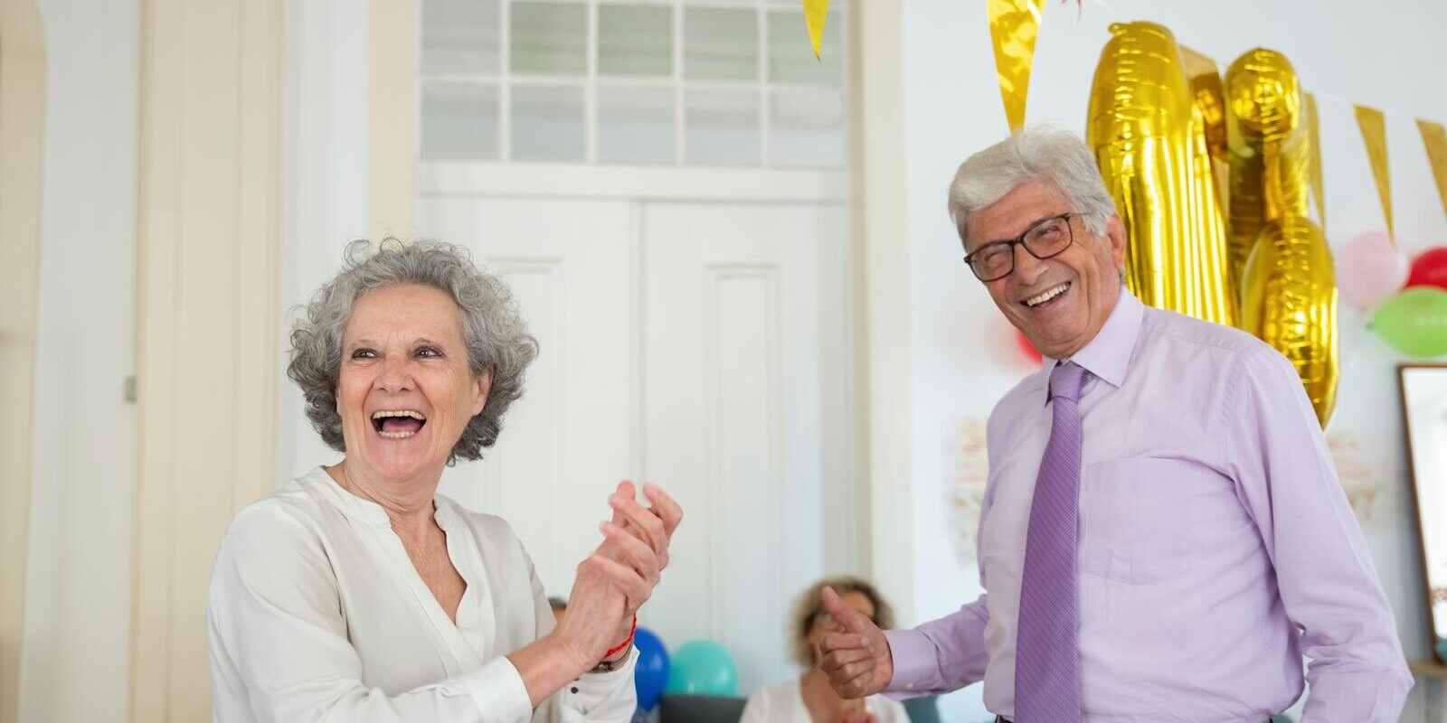 Happy seniors celebrating indoors with balloons and laughter. Perfect for festive and joyful lifestyle themes.